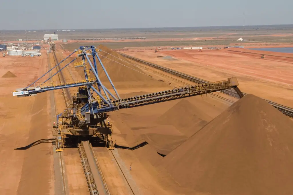 Stacker reclaimer operating on crane rails secured with heavy-duty rail clips